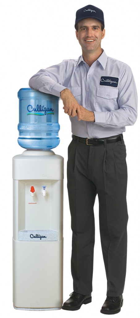 Culligan Man Standing Next to Bottled Water Cooler.